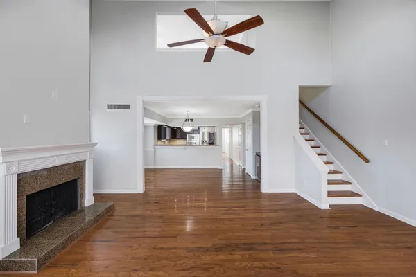 a view of empty room with wooden floor and fireplace