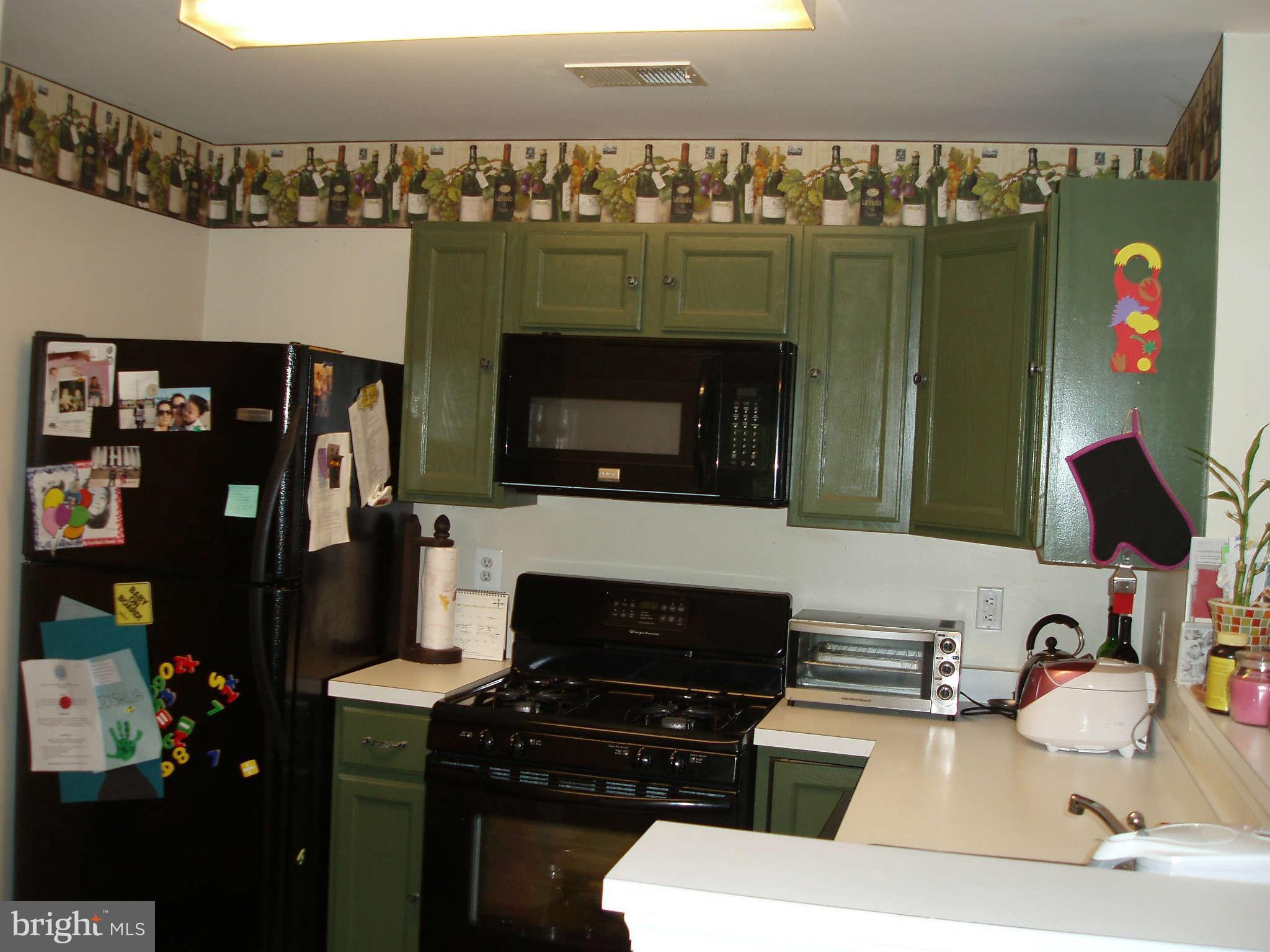 1049 Gardenview Loop, Unit 301 Woodbridge, VA 22191 - Photo 4 of 16 a kitchen with a sink appliances and cabinets