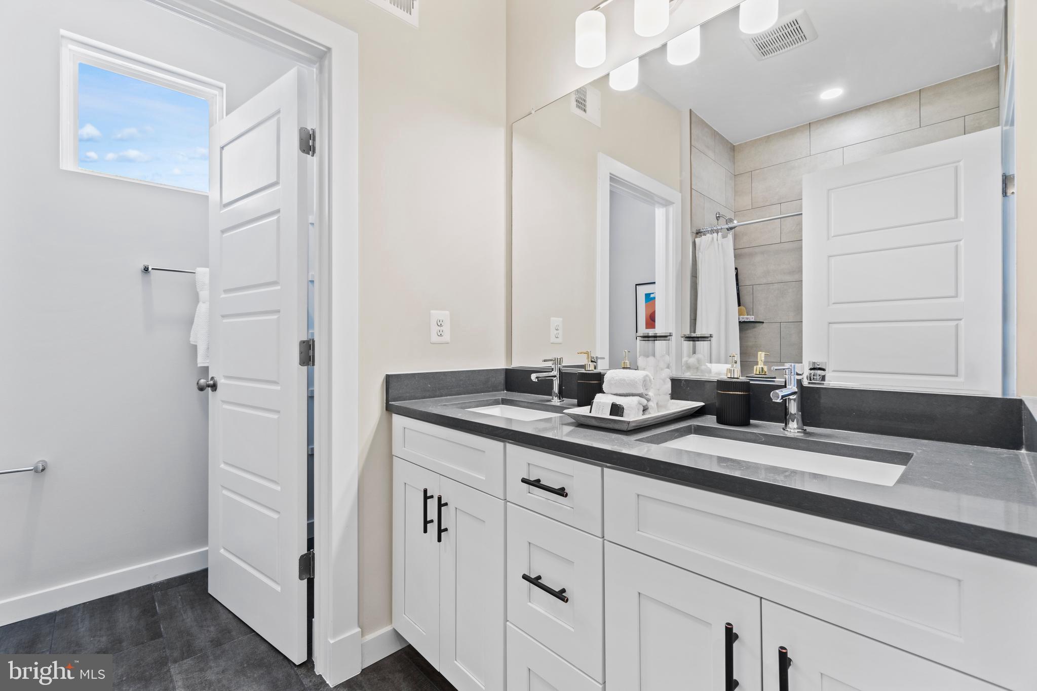 129 Summit Point Boulevard, Unit 11J Bowie, MD 20716 - Photo 22 of 45 a bathroom with a double vanity sink and a mirror