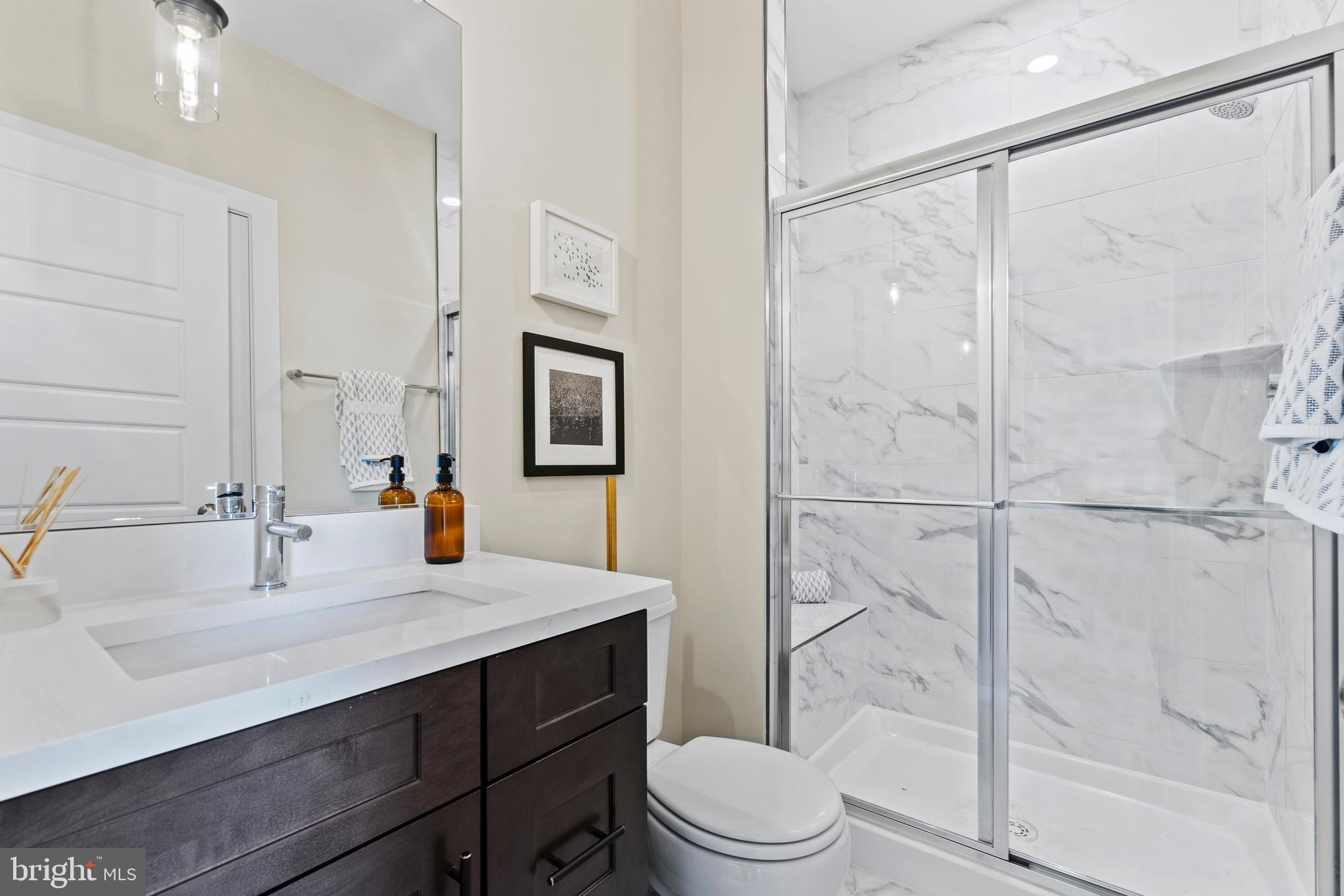 129 Summit Point Boulevard, Unit 11J Bowie, MD 20716 - Photo 25 of 45 a bathroom with a sink toilet a mirror and shower