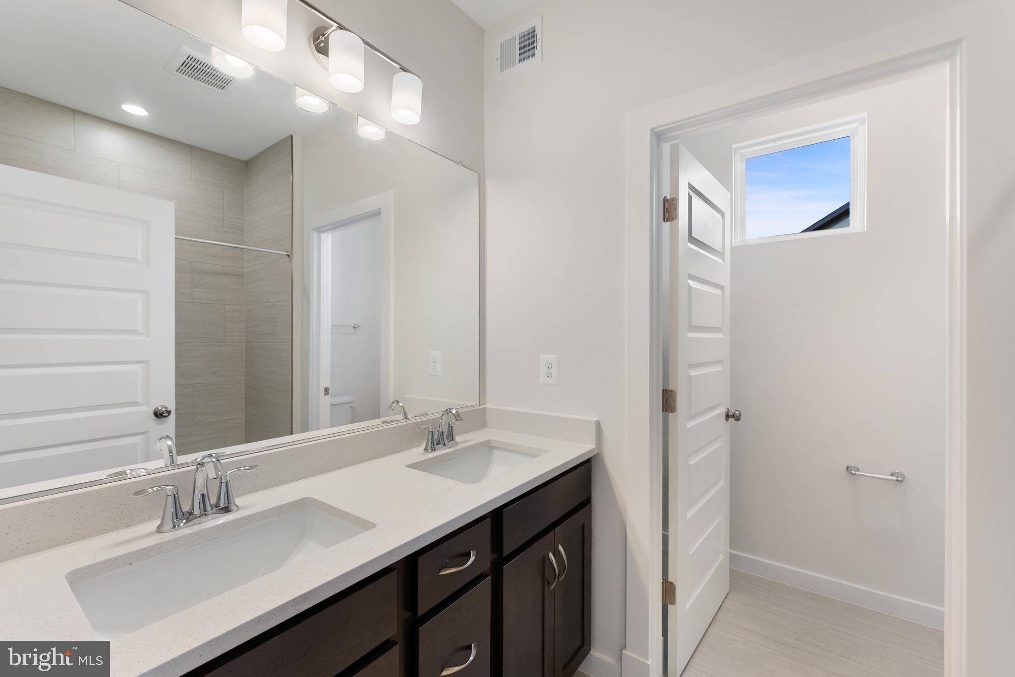 129 Summit Point Boulevard, Unit 11J Bowie, MD 20716 - Photo 40 of 45 a bathroom with a sink double vanity and a mirror