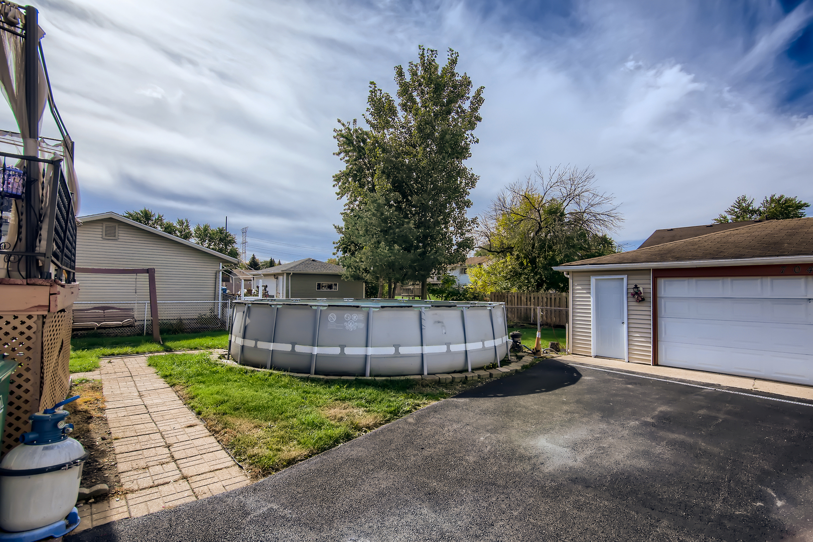 704 Evergreen Court Romeoville, IL 60446 - Photo 11 of 15 a view of a backyard with potted plants and a large tree