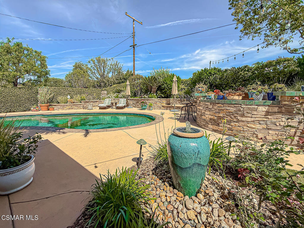 3116 Lori Circle Simi Valley, CA 93063 - Photo 52 of 74 a view of a swimming pool with a table and chairs potted plants