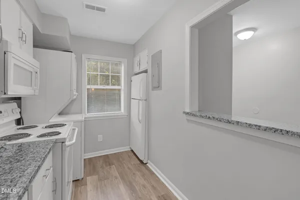 a kitchen with granite countertop a sink and a stove top oven