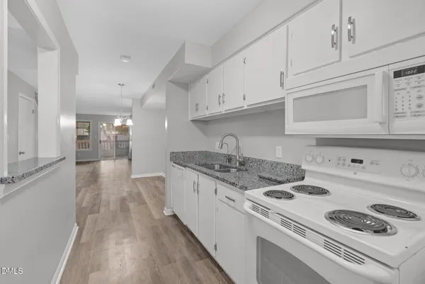 a kitchen that has a stove and a wooden floor