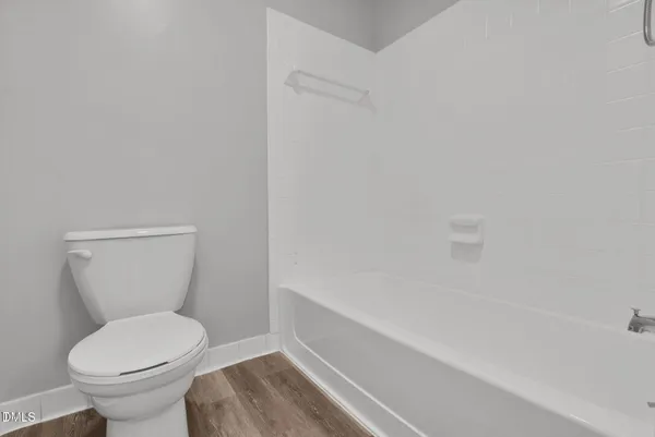 a white toilet sitting next to a shower