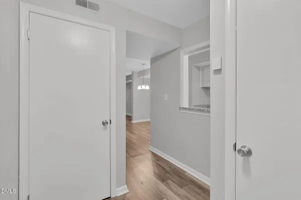 a view of a hallway with wooden floor