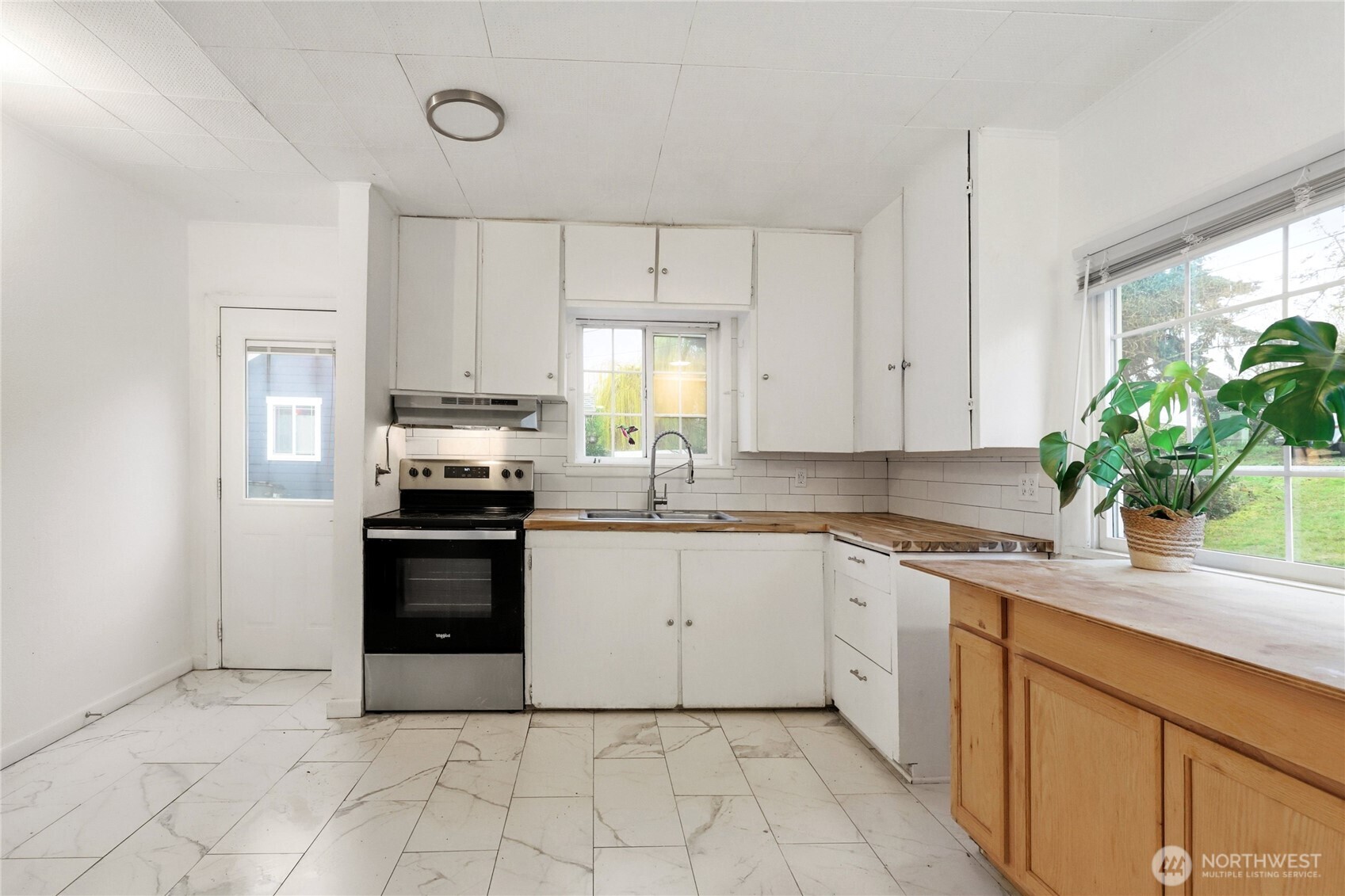 1505 Retsil Road Southeast Port Orchard, WA 98366 - Photo 7 of 19 a kitchen with white cabinets stainless steel appliances and a window