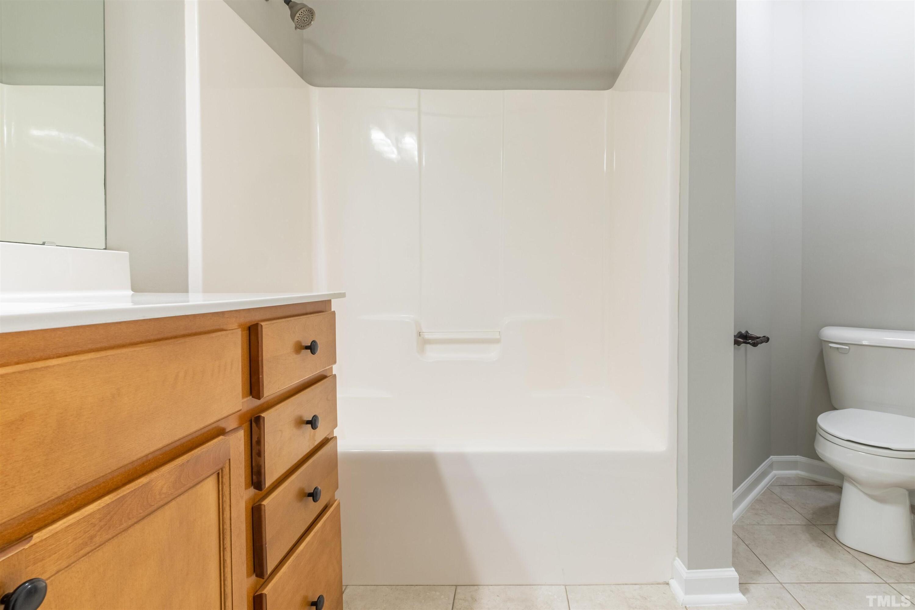 125 Old Grove Lane Apex, NC 27502 - Photo 18 of 30 a bathroom with a sink a toilet and a mirror