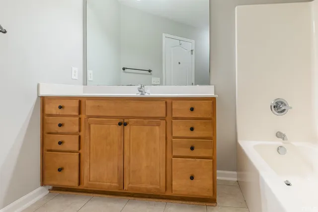 a bathroom with a tub sink and mirror