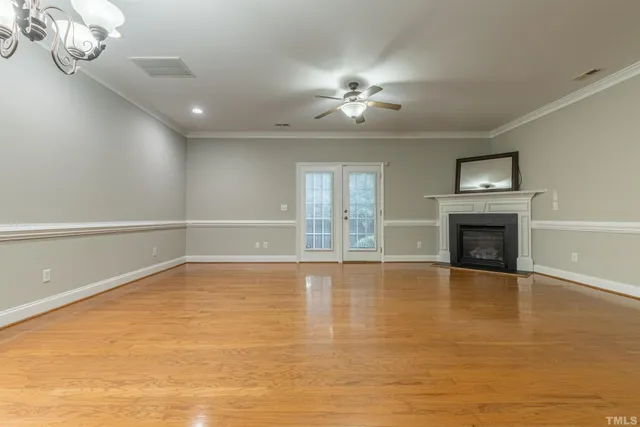 a view of an empty room with a fireplace and chandelier