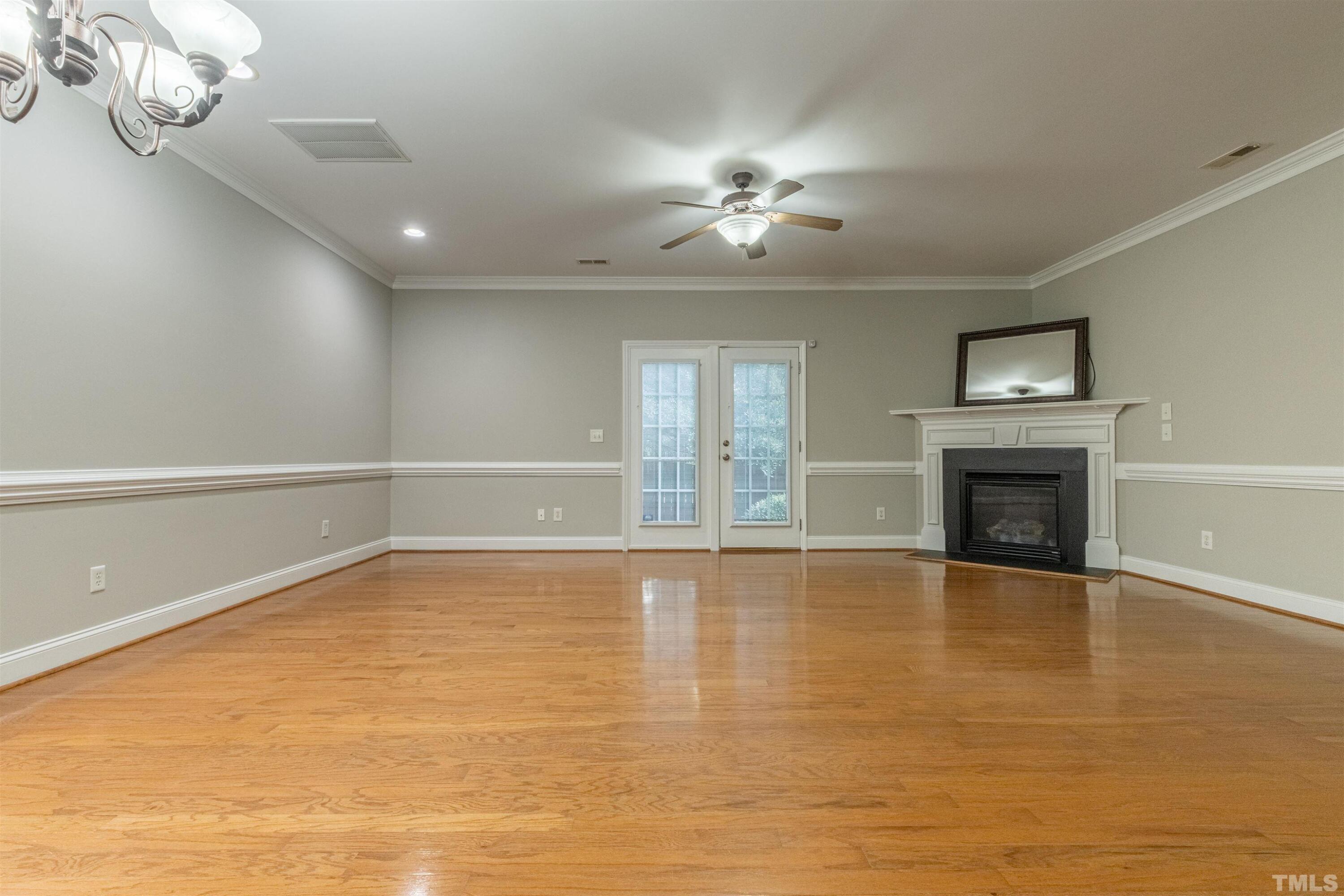 125 Old Grove Lane Apex, NC 27502 - Photo 4 of 30 a view of an empty room with a fireplace and chandelier
