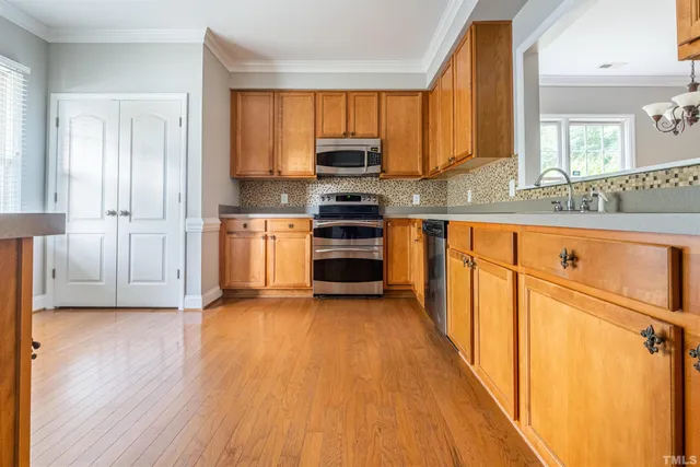a kitchen with granite countertop wooden floors and stainless steel appliances