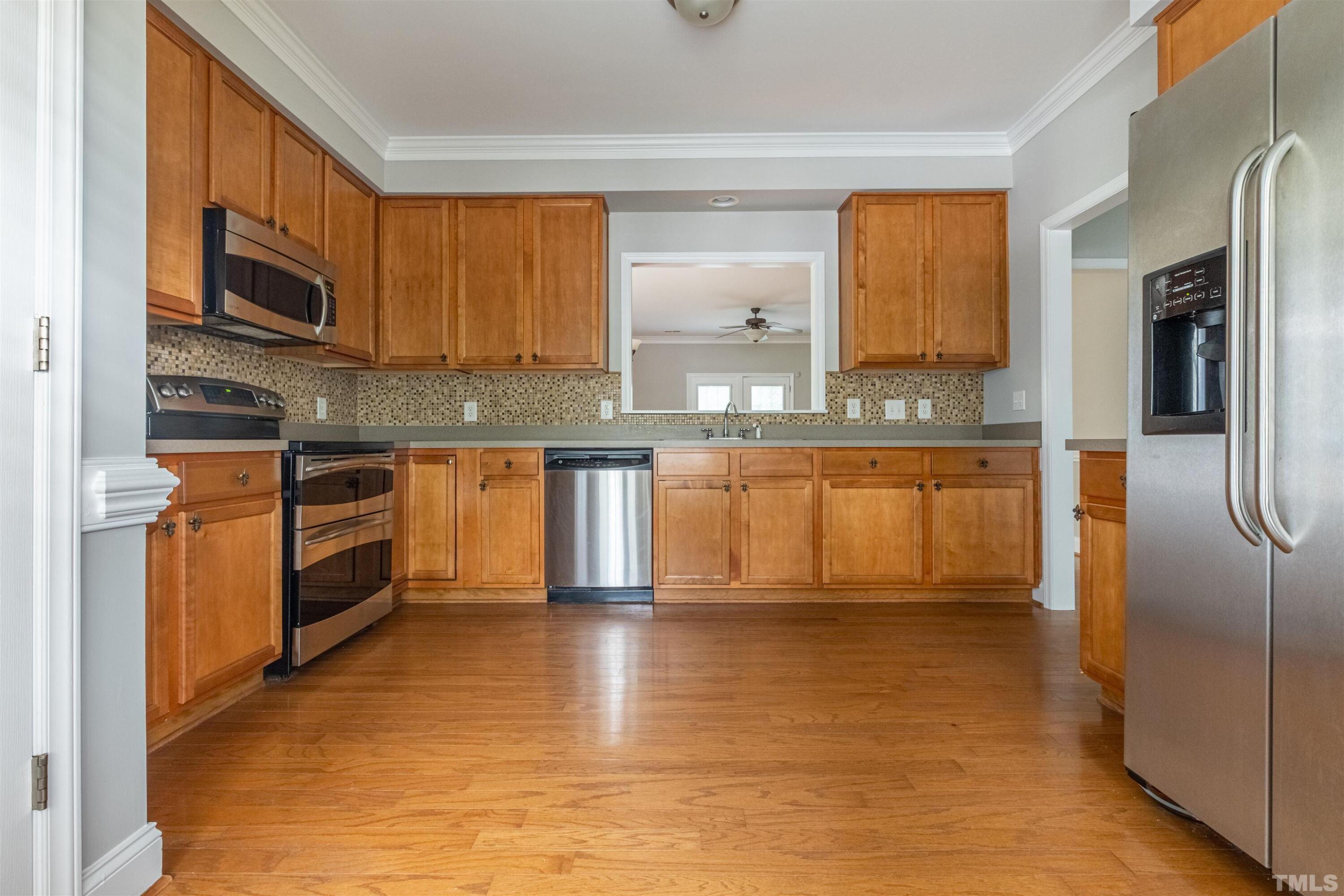 125 Old Grove Lane Apex, NC 27502 - Photo 7 of 30 a kitchen with stainless steel appliances granite countertop a refrigerator a stove top oven a sink and dishwasher