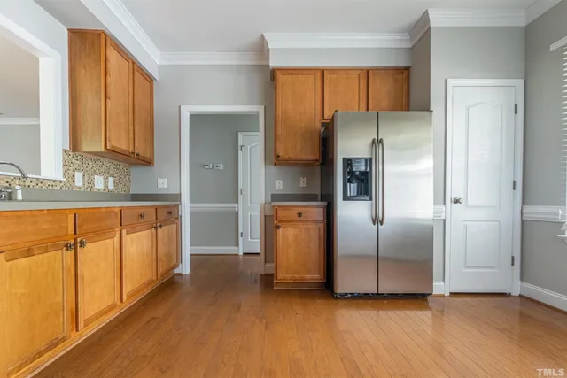 a kitchen with stainless steel appliances granite countertop a refrigerator and a sink