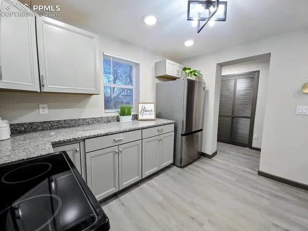 a kitchen with stainless steel appliances granite countertop a refrigerator a sink dishwasher a stove and a microwave oven on granite countertops
