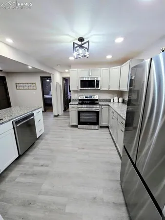 a large kitchen with stainless steel appliances granite countertop a stove sink and refrigerator