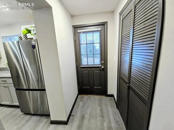 a view of a hallway with wooden floor and door