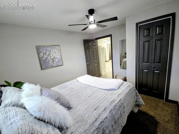 a bedroom with a large bed and a chandelier