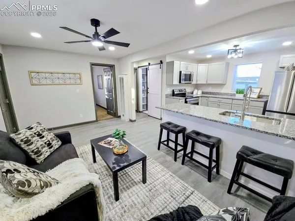 a living room with furniture and view of kitchen