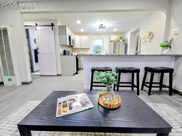 a living room with kitchen island furniture and a table