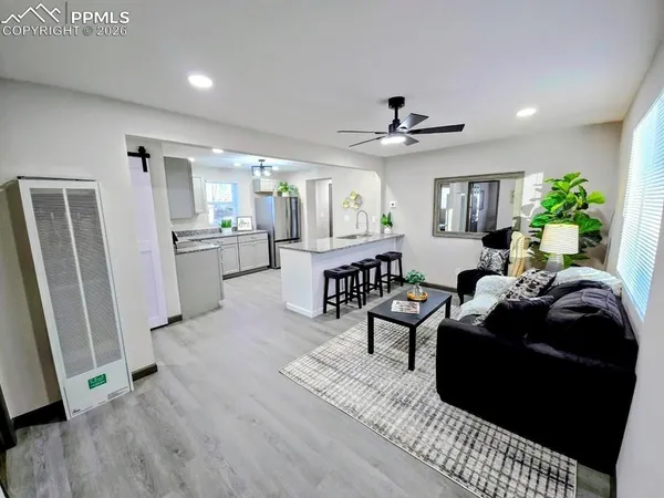 a living room with furniture a fireplace and a chandelier