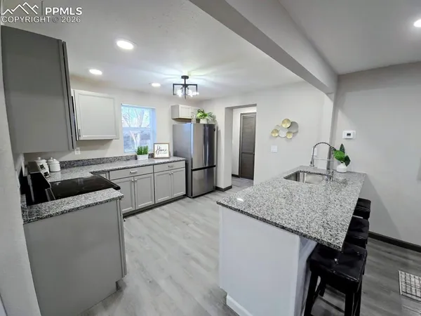 a kitchen with a table chairs sink and cabinets