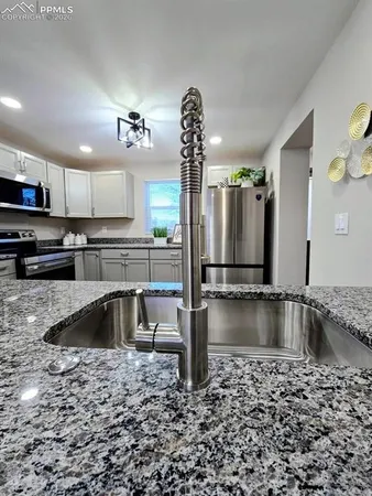 a kitchen with stainless steel appliances granite countertop a sink stove and refrigerator