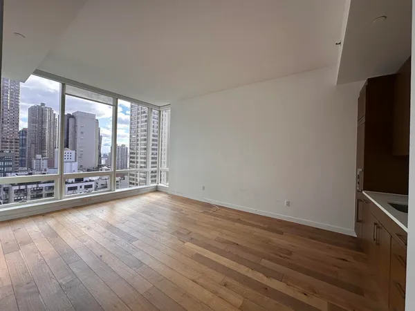 a view of a room with wooden floor and large window