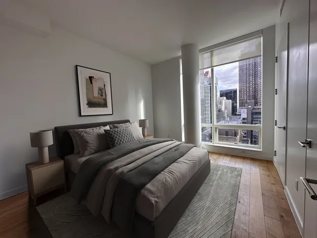 a bedroom with bed and a large window