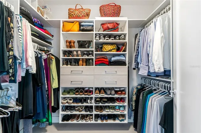 a view of walk in closet with clothes and shoes