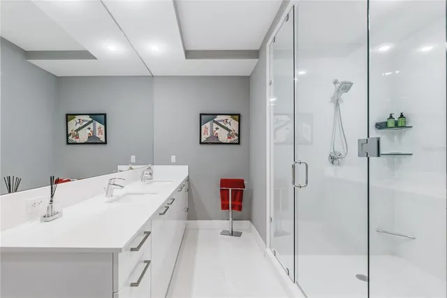 a en suite bathroom with a double vanity sink a mirror and a shower