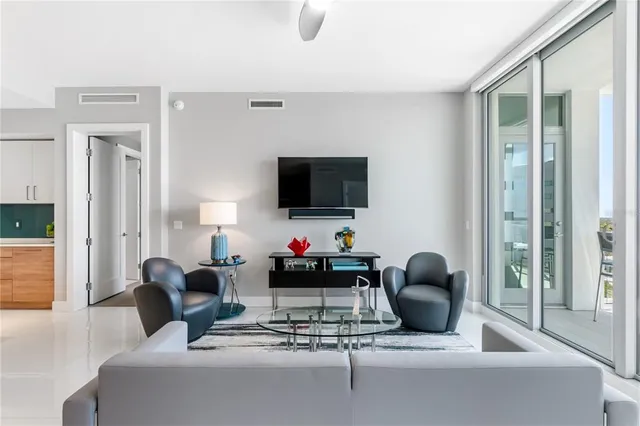 a living room with furniture a flat screen tv and a floor to ceiling window
