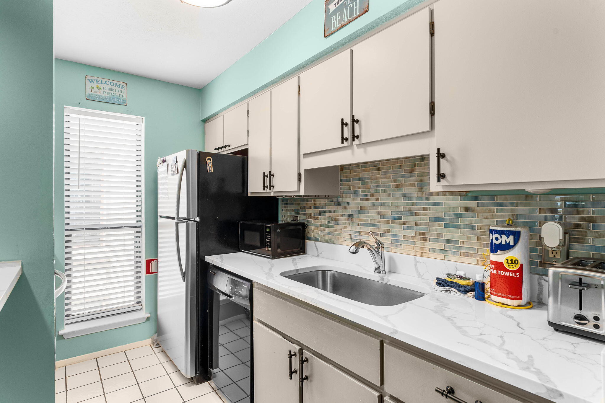 17614 Front Beach Road, Unit D13 Panama City Beach, FL 32413 - Photo 14 of 46 a kitchen with stainless steel appliances a sink a refrigerator and cabinets