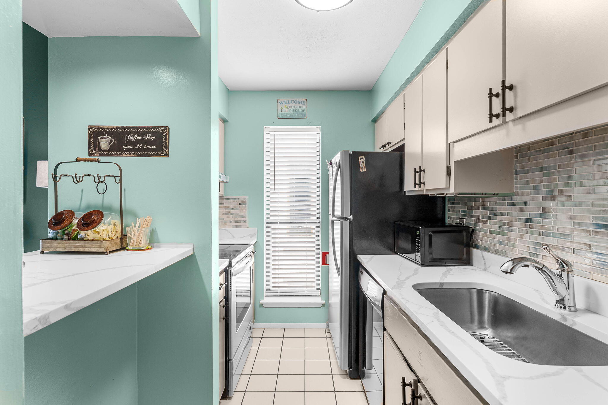 17614 Front Beach Road, Unit D13 Panama City Beach, FL 32413 - Photo 4 of 46 a kitchen with a sink cabinets and utility