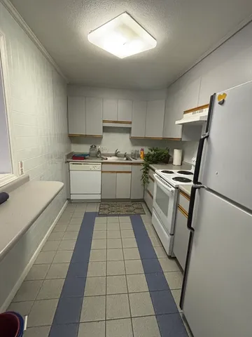a kitchen with a sink a stove top oven and cabinets