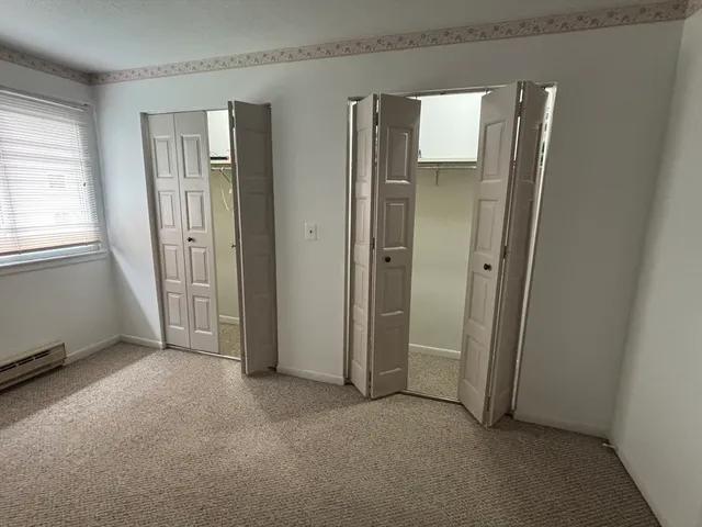 an empty room with windows and closet