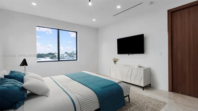 a bedroom with a bed and a flat screen television