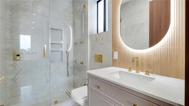 a bathroom with a sink a toilet and shower