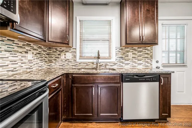 a kitchen with granite countertop stainless steel appliances and wooden cabinets