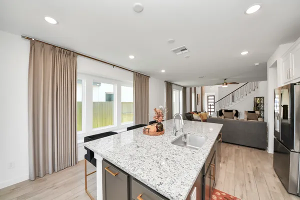 a kitchen with stainless steel appliances granite countertop sink refrigerator and wooden floor