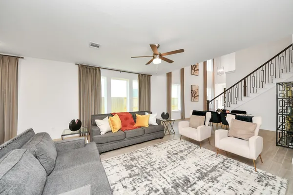 a living room with furniture ceiling fan and a rug