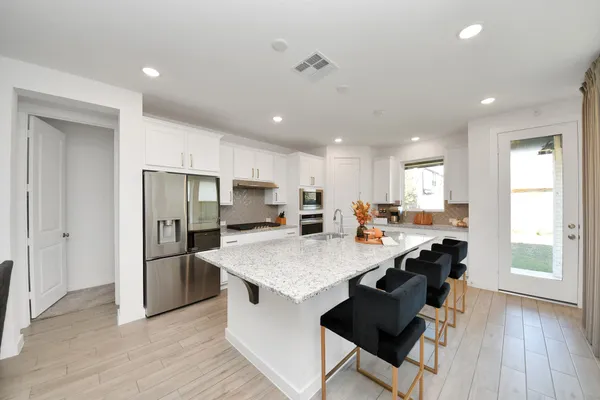 a kitchen with stainless steel appliances a refrigerator and a stove top oven
