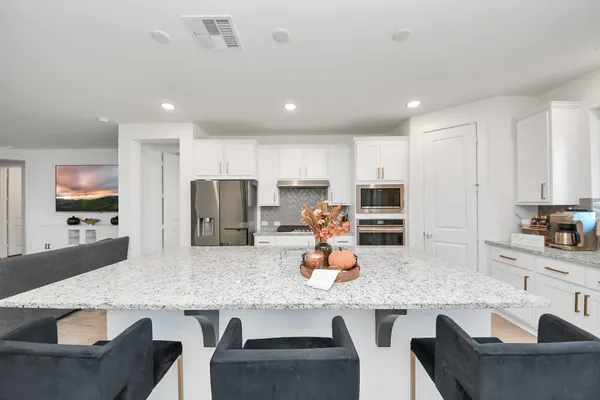 a kitchen with stainless steel appliances granite countertop white cabinets a sink and a stove
