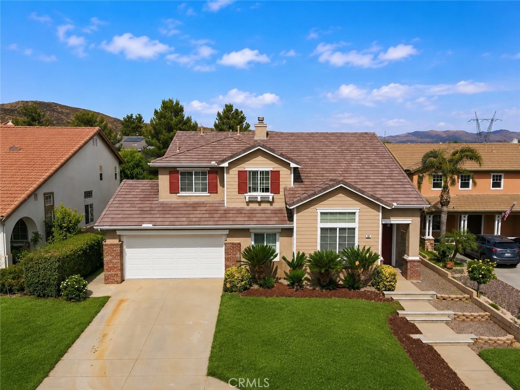 152 Alabaster Loop Perris, CA 92570 - Photo 3 of 29 a front view of a house with a yard and potted plants