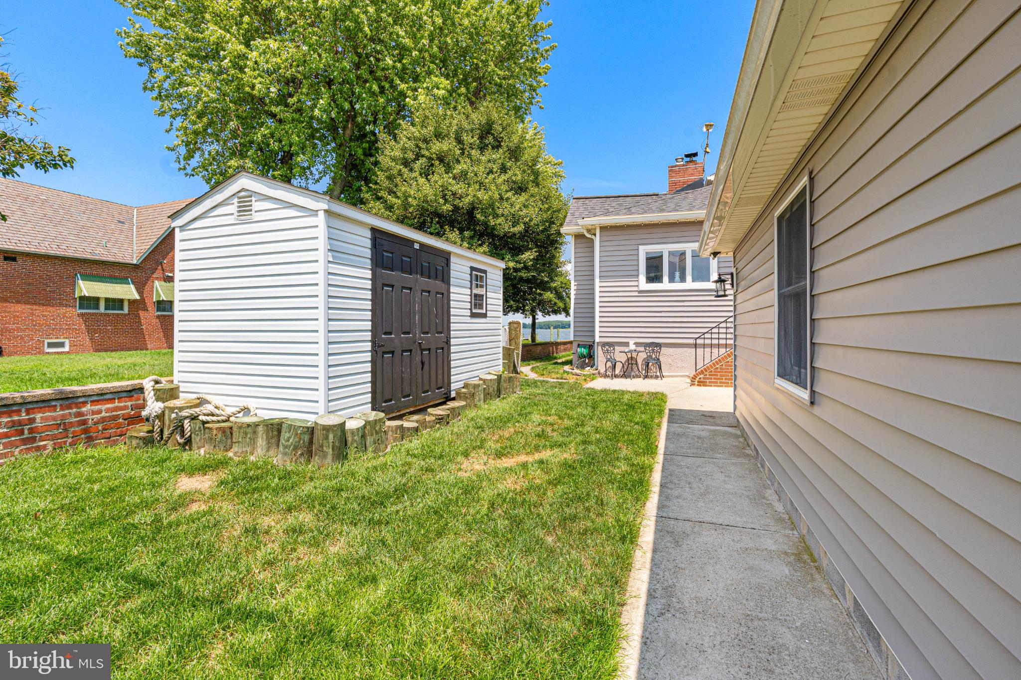 7118 River Drive Road Sparrows Point, MD 21219 - Photo 5 of 52 Charming backyard with storage shed and greenery.