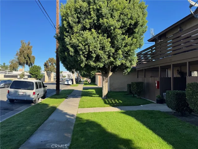 a view of a yard with a car parked in front of house
