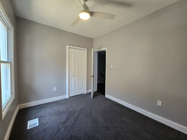 an empty room with closet and windows