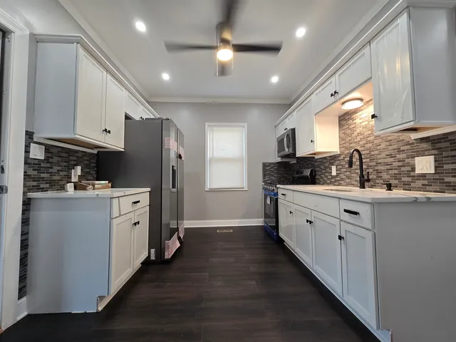a kitchen with white cabinets and stainless steel appliances