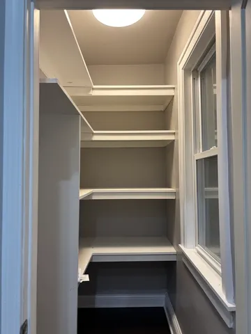 a view of walk in closet with empty racks